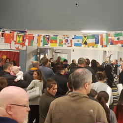Crowd of people walking down hall of school