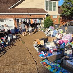 Man looking through items at a yard sale.