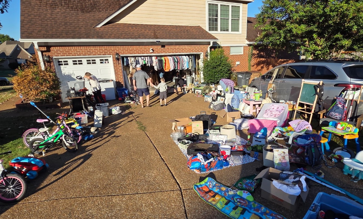 Man looking through items at a yard sale.