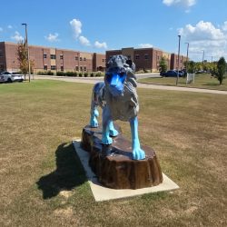 Lion statue in front of LPS during daylight.