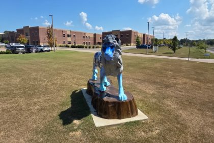 Lion statue in front of LPS during daylight.
