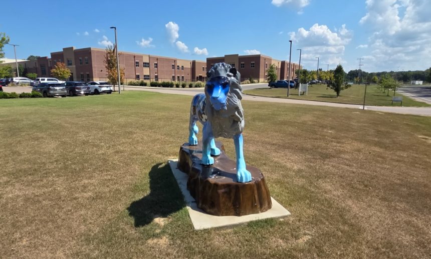 Lion statue in front of LPS during daylight.
