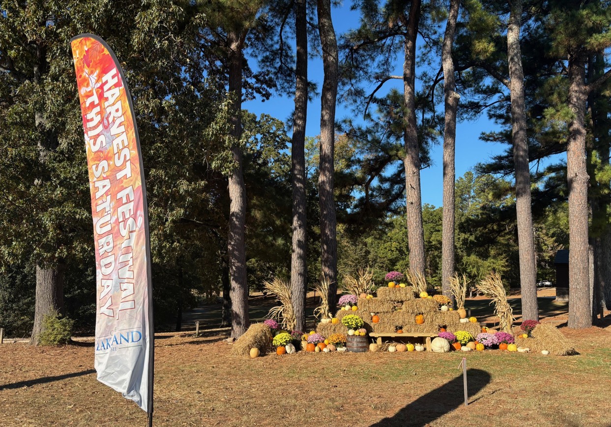 Harvest festival flag with fall decorations in the background outside.
